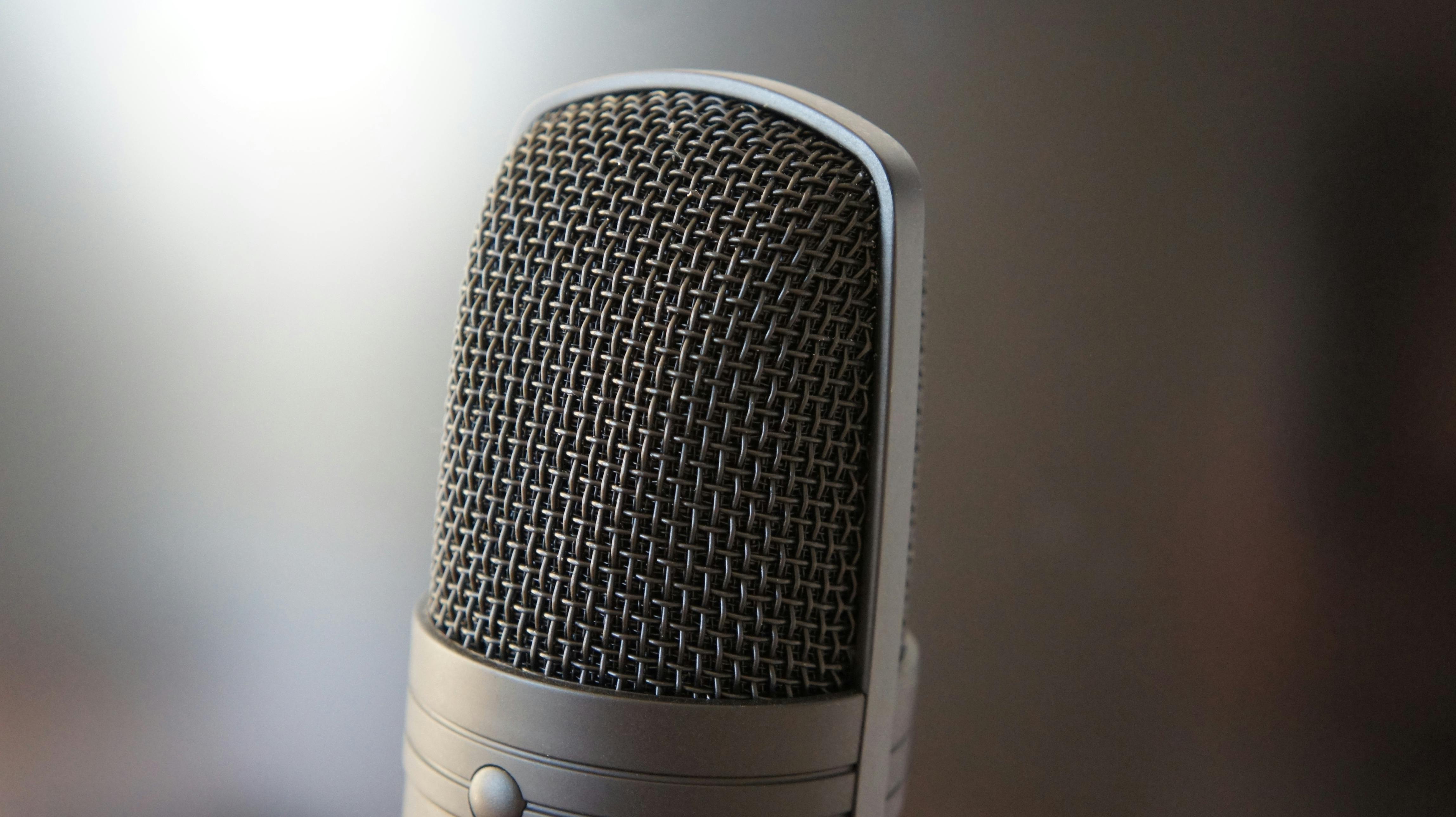 Detailed view of a professional condenser microphone with a blurred backdrop, ideal for audio equipment themes.